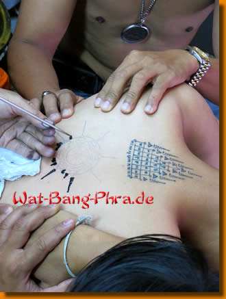 Der Mönch Luang Pi Nunn sticht einer Frau ein Yantra Tattoo