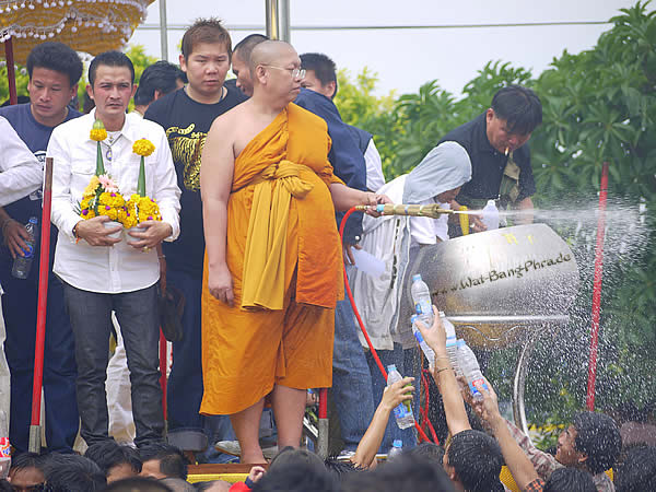 Mönch segnet Sak Yant mit geweihtem heiligem Wasser